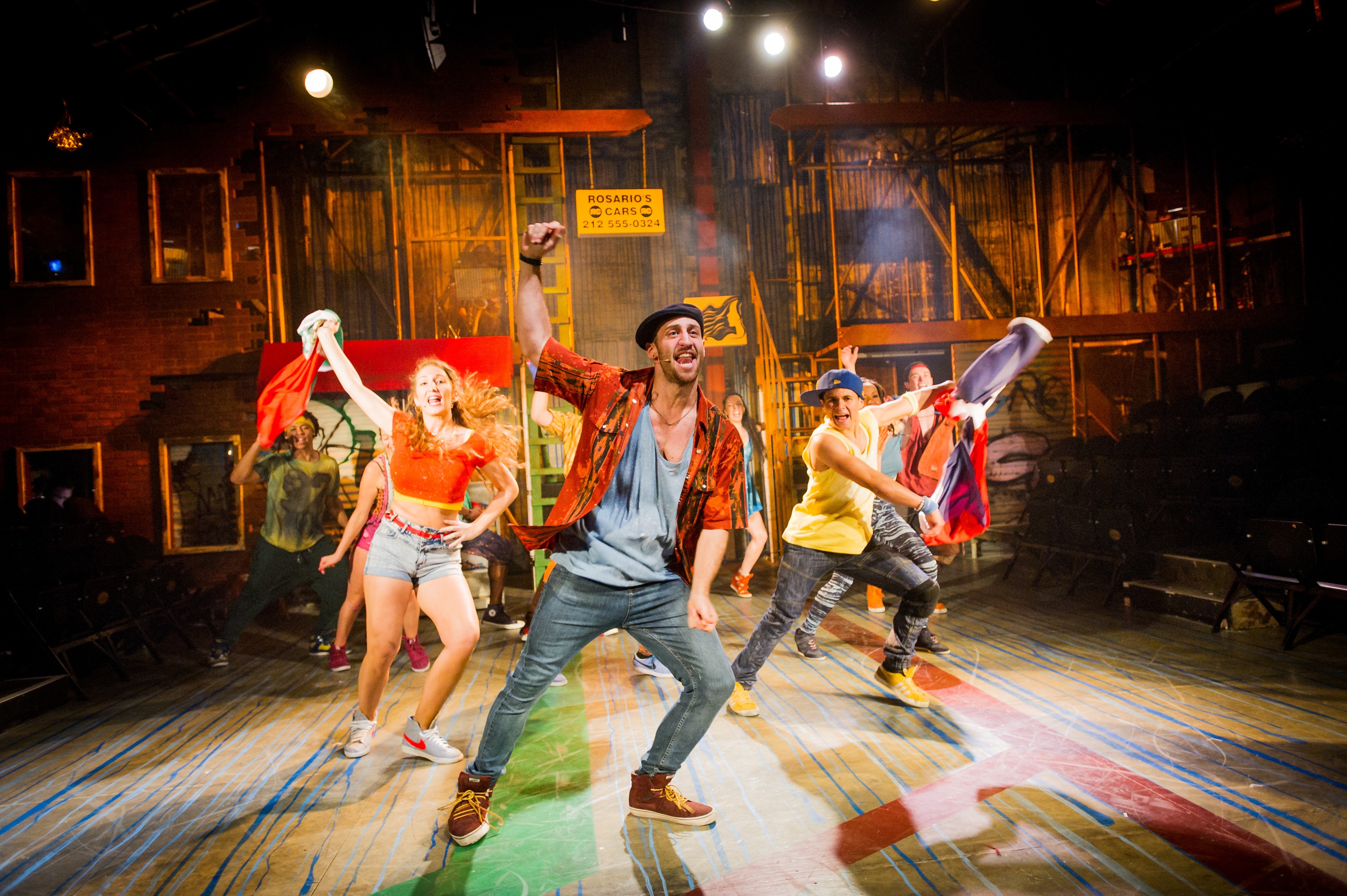 Sam Mackay as Usnavi and The Company of IN THE HEIGHTS. Photo Credit Robert Workman